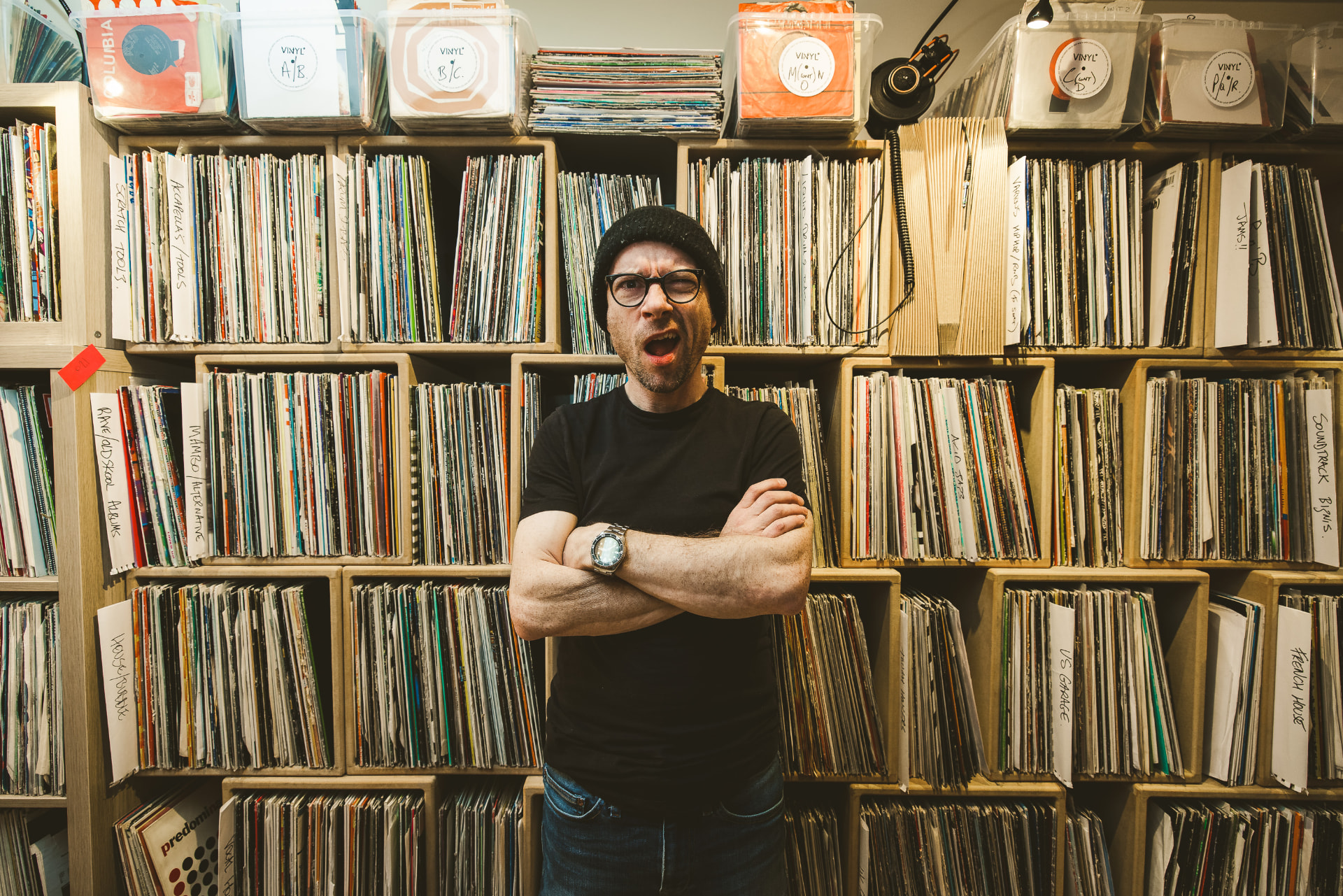 Chris Bailey in front of his wall of vinyl records